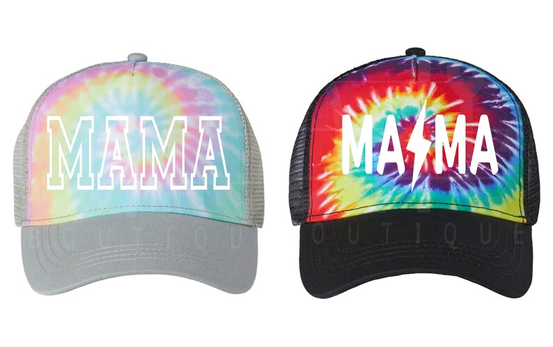 May include: Two tie-dye trucker hats with the word "MAMA" written in white on the front. The hat on the left has a pastel tie-dye pattern and a gray mesh back. The hat on the right has a red, orange, yellow, green, blue, and purple tie-dye pattern and a black mesh back. The hat on the right also has a lightning bolt in the word "MAMA".