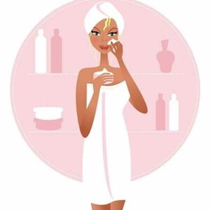 May include: A woman with a towel wrapped around her is applying a white cream to her face. She is standing in front of a pink bathroom counter with various bottles and jars of toiletries.
