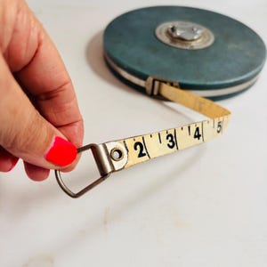 Puede incluir: Juego de tres tazas de cerámica con un esmalte moteado de color crema. Cada taza presenta un diseño floral pintado a mano en tonos azules, verdes y amarillos. Las tazas tienen una forma simple y redondeada y un asa.