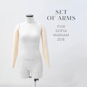 Op de afbeelding: Een witte stoffen paspop-torso met bevestigde lichtbeige stoffen armen. De tekst SET OF ARMS FOR SOFIA MARIAM ZOE staat in het zwart aan de rechterkant gedrukt. De paspop heeft een hoge hals, gedefinieerde schouders en een gestructureerde taille.