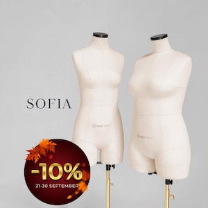May include: Two beige fabric-covered dress forms on adjustable gold-toned metal stands. The forms feature visible seam lines and black neck caps. The text SOFIA is displayed to the left, alongside a circular graphic with autumn leaves and -10%.