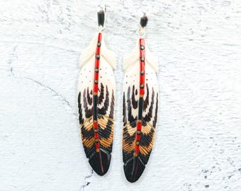 Colgante de pluma de hueso de búfalo de agua tallado y pintado a mano, 1 unidad. 63 x 15 mm, motivos en rojo, marrón y negro.