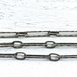 May include: Three rows of a silver chain with a hammered texture. The chain links are oval shaped.