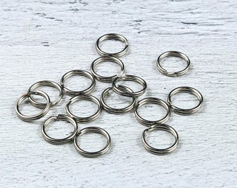 May include: A collection of silver-toned metal jump rings, ideal for jewelry making or crafting projects.