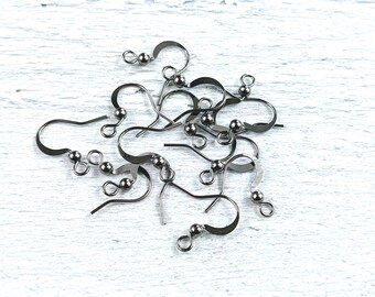 May include: A close-up of a pile of silver-toned earring hooks. The hooks are made of metal and have a small ball at the top. They are designed for making earrings.