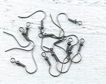 May include: A close-up of a group of black earring hooks with spring-loaded clasps. The hooks are made of metal and have a shiny finish.