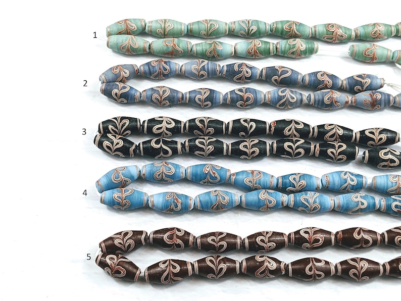 May include: Five strands of glass beads with a swirling pattern. The beads are in shades of blue, green, brown, and black. Each strand has a number next to it.