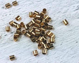 May include: A pile of gold-coloured metal crimp beads, used for jewellery making.