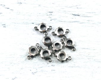 May include: Silver-toned metal flower-shaped connector charms with two loops on each charm. The charms are scattered on a white surface.