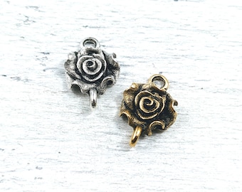 May include: Two silver and gold rose charms with a loop at the top. The charms are in the shape of a rose with a swirl design.