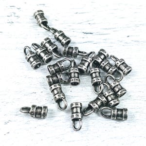 May include: A group of silver metal end caps for jewelry making. The end caps have a decorative design and are perfect for adding a touch of elegance to your jewelry.