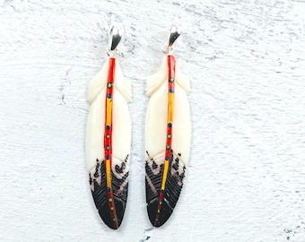 Colgante de pluma de hueso de búfalo de agua tallado y pintado a mano, 1 pieza, 63 x 15 mm, con motivos en rojo, amarillo, azul y marrón.