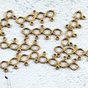 May include: Gold-toned metal chain links with a decorative, textured design. Each link has multiple small holes for attaching to other jewellery pieces.
