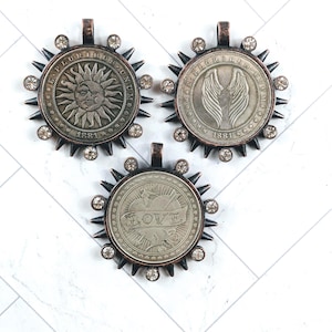 Plaqué bronze huilé et strass Amour, pendentifs répliques de pièces d'ailes d'ange ou soleil et lune, médaillon, lunette, 38 mm, 1 pièce.