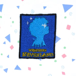 Könnte beinhalten: Blauer gestickter Aufnäher mit einer Silhouette eines Kinderkopfes und den Worten "Neverland" in goldener Schrift.