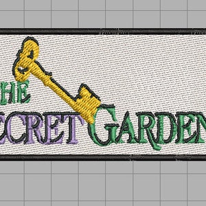 Puede incluir: Un parche blanco bordado con un borde negro. El parche presenta una llave amarilla con un texto verde "THE SECRET GARDEN".