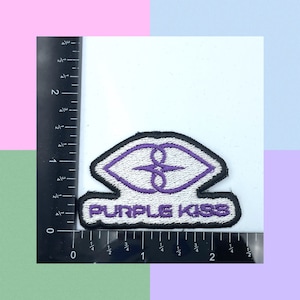 May include: Purple Kiss embroidered patch with a white background and purple lips design. The text "Purple Kiss" is embroidered in white on a black banner.