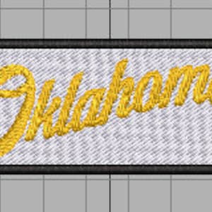 May include: A white embroidered patch with a black border. The patch features the word "Oklahoma!" in a gold cursive font.