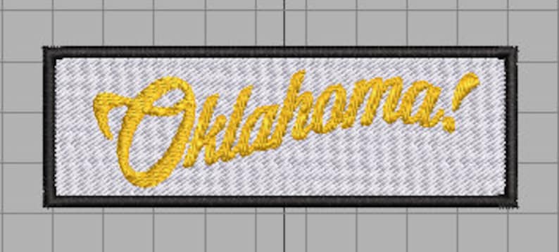 May include: A white embroidered patch with a black border. The patch features the word "Oklahoma!" in a gold cursive font.