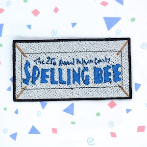 May include: A white and blue embroidered patch with the text "The 25th Annual Putnam County Spelling Bee".