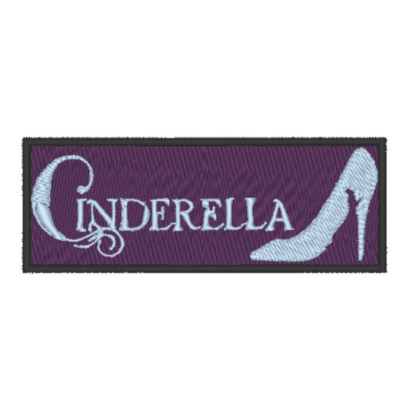May include: A purple embroidered patch with a white outline and the word "Cinderella" in white cursive lettering. A white glass slipper is embroidered on the right side of the patch.
