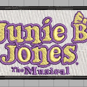 Puede incluir: Un parche bordado de color morado y amarillo con el texto "Junie B. Jones the Musical" y un lazo morado.