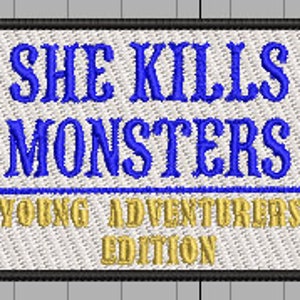 May include: Blue and gold embroidered patch with the text "She Kills Monsters Young Adventurers Edition".