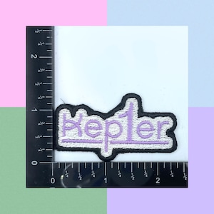 Può includere: Toppa ricamata viola con la parola "Kepler" in contorno bianco e bordo nero.