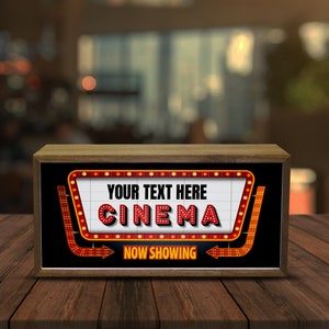 Puede incluir: Una caja de madera con un letrero de estilo marquesina rojo y blanco que dice "YOUR TEXT HERE CINEMA NOW SHOWING".