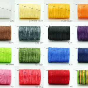 May include: A collection of 16 spools of waxed cotton cord in various colours, including white, champagne yellow, golden yellow, pumpkin, brown, slate grey, black, purple, lime green, pea green, blue, royal blue, pink, hot coral, red, and rainbow.