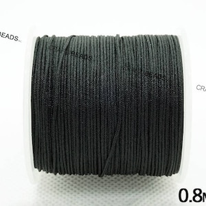 May include: A spool of black cord, 0.8 mm thick, for crafting and jewelry making.
