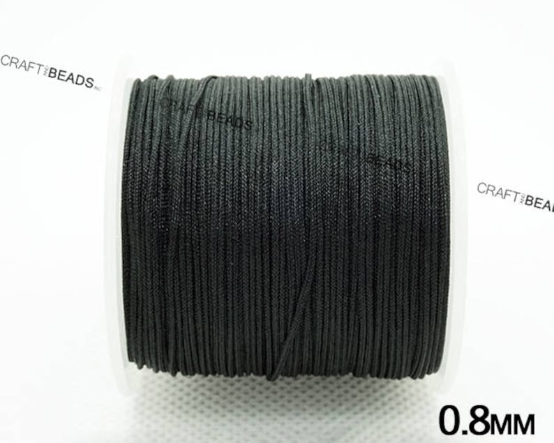 May include: A spool of black cord, 0.8 mm thick, for crafting and jewelry making.
