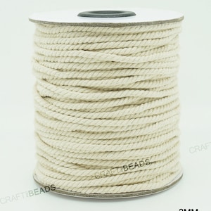 Pu&ograve; includere: Un rotolo di cordoncino in cotone bianco naturale, di 3 mm di spessore, per progetti di artigianato e fai-da-te. Il cordoncino &egrave; avvolto attorno a un rotolo di cartone bianco con un'etichetta nera che recita "CRAFT BEADS".