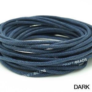 May include: A spool of dark blue waxed cotton cord. The cord is wound tightly and is ready to be used for crafting projects.