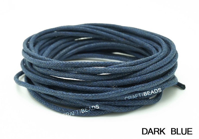 May include: A spool of dark blue waxed cotton cord. The cord is wound tightly and is ready to be used for crafting projects.