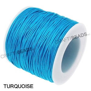 May include: A spool of turquoise waxed cotton cord. The cord is wound around a white plastic spool.