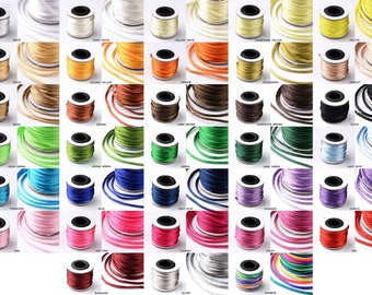 May include: Assortment of 25 spools of satin cord in various colors, including white, peach, yellow, orange, brown, green, blue, pink, red, burgundy, silver, and rainbow. Each spool is wound with a thin, silky cord.