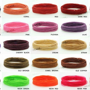 K&ouml;nnte beinhalten: Eine Sammlung von 20 Spulen mit farbigem gewachstem Garn, jede in einem Kreis gewickelt. Die Farben umfassen Blau, Schwarz, Koralle, Rot, Dunkelrot, Burgunder, Hellrosa, Rosa, Fuchsia, Lila, Mauve, Lila, Kirschschwarz, Creme, Stroh, Braun, Altgold, Altbronze, Kamelbraun, Altcopper, Braun, Schokoladenbraun, Neongr&uuml;n, Neonrot, Neonrosa und Neonkoralle.