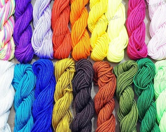 Puede incluir: Surtido de 20 carretes de cordón de algodón encerado de colores, cada carrete tiene aproximadamente 91 metros de largo. Los cordones están dispuestos en una fila, con cada color visible. Los colores incluyen blanco, morado, naranja, amarillo, verde, azul, rojo, marrón y negro.