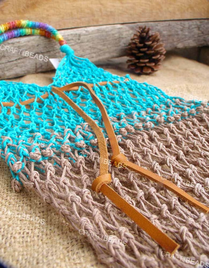 May include: A turquoise and brown crocheted net bag with leather straps. The bag has a rainbow colored handle.