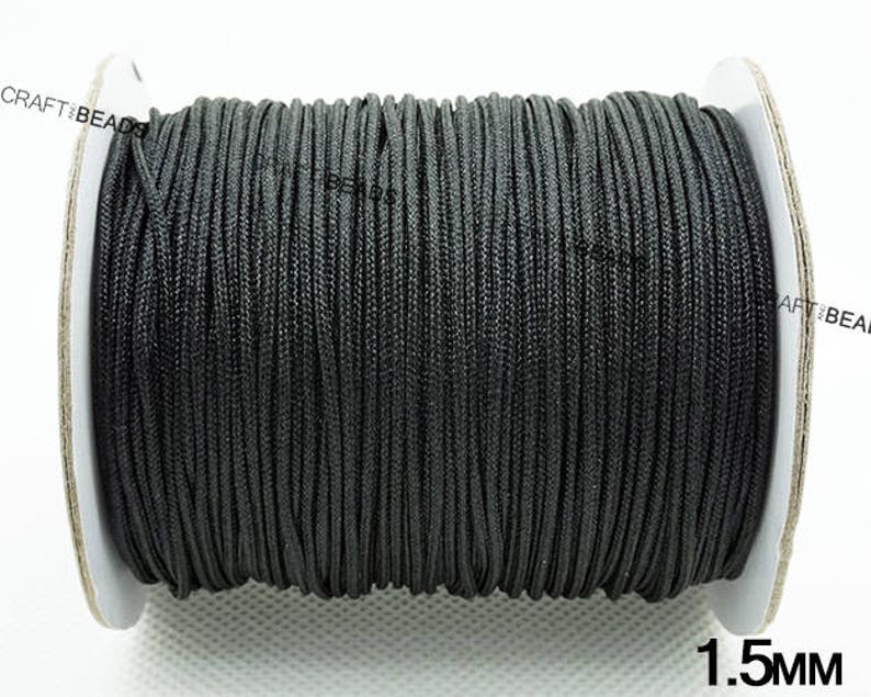 May include: A spool of black cord with a 1.5 mm diameter. The cord is wound tightly around the spool, which is made of white cardboard.