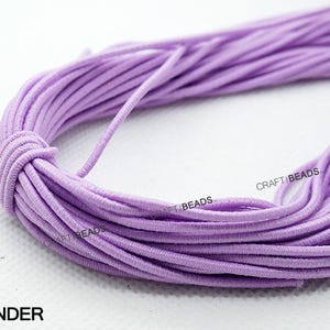 K&ouml;nnte beinhalten: Eine Spule mit lila elastischem Band. Das Band ist weich und dehnbar, perfekt f&uuml;r die Herstellung von Schmuck, Bastelarbeiten und anderen Projekten.