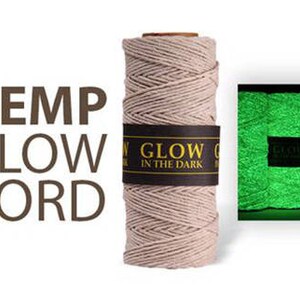 Könnte beinhalten: Eine Spule aus natürlicher Hanfschnur, die im Dunkeln leuchtet. Die Schnur ist beige und hat ein schwarzes Etikett mit der Aufschrift "Glow in the Dark".