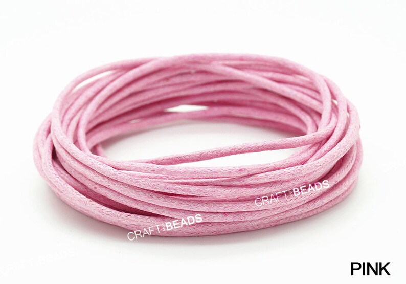 May include: A spool of pink waxed cotton cord. The cord is wound tightly and is ready to be used for crafting projects.