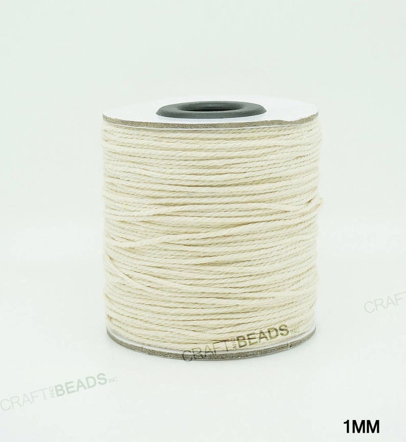 Pu&ograve; includere: Un rotolo di cordoncino in cotone bianco naturale da 1 mm di spessore. Il cordoncino &egrave; avvolto attorno a un rotolo di cartone bianco con un centro in plastica nera.