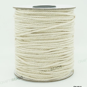 Pu&ograve; includere: Un rotolo di cordoncino in cotone bianco naturale, di 2 mm di spessore, avvolto attorno a un rotolo di cartone bianco. Il cordoncino &egrave; utilizzato per l'artigianato e la creazione di gioielli.