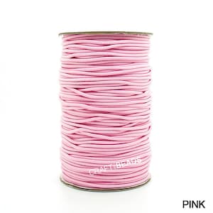 May include: A spool of pink elastic cord, perfect for crafting and jewelry making.