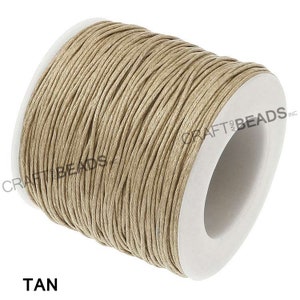 May include: A spool of tan waxed cotton cord, wound around a white cardboard tube. The label on the tube reads "Craft and Beads Inc."