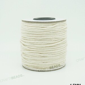 Pu&ograve; includere: Un rotolo di cordoncino in cotone bianco naturale da 1,5 mm di spessore. Il cordoncino &egrave; avvolto attorno a un rotolo di cartone bianco con un centro nero.