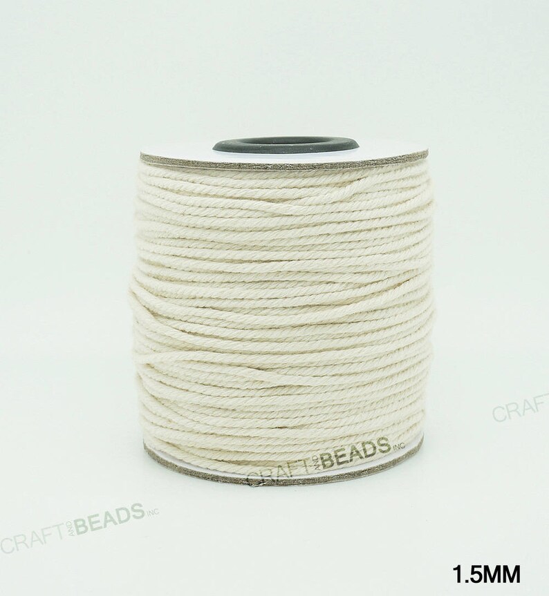 Pu&ograve; includere: Un rotolo di cordoncino in cotone bianco naturale da 1,5 mm di spessore. Il cordoncino &egrave; avvolto attorno a un rotolo di cartone bianco con un centro nero.